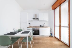 Cucina moderna attrezzata con forno tavolo pranzo e sedie appartamento vacanze Monza