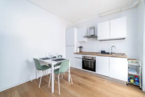 Cucina moderna attrezzata con forno tavolo pranzo e sedie appartamento vacanze Monza